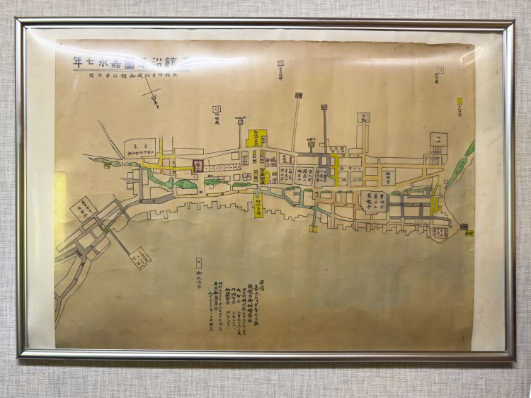 Según una réplica del mapa histórico de Hakodate publicado en 1854, el Santuario Hakodate Hachimangu está ubicado ligeramente a la izquierda del centro, rodeado de rojo, y hay una puerta torii al final del camino (pendiente) frente a él.