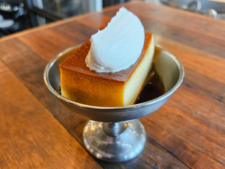 La textura firme del “Egg Baby Pudding” combina perfectamente con crema fresca y salsa de caramelo.