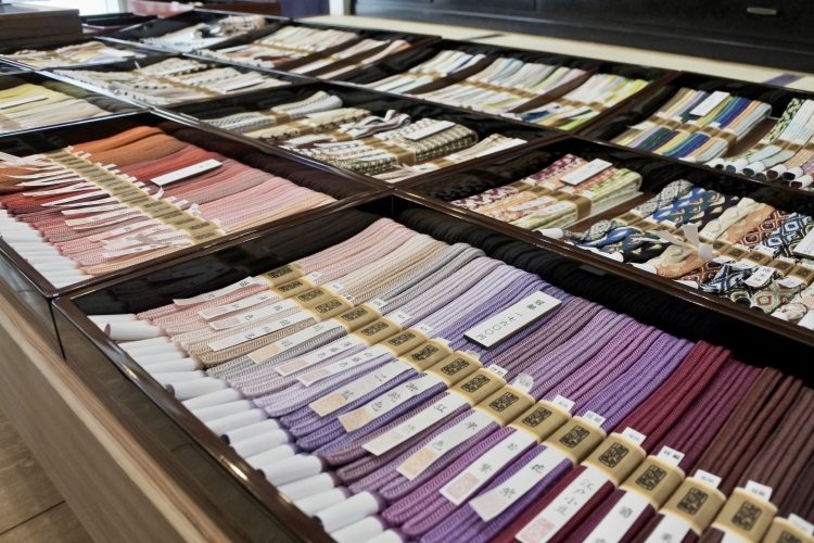 Los cinturones obi están alineados en un espacio abarrotado. Los cordones, teñidos y tejidos a mano, crean un degradado vibrante.