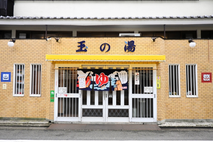 El exterior, con sus azulejos amarillos y las palabras "Tama no Yu", llama la atención.