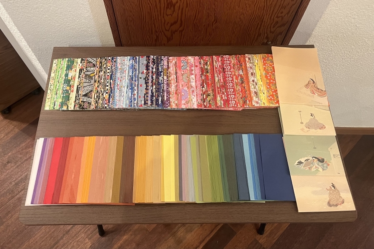 Elige dos trozos de papel chiyogami con tus colores y diseños favoritos y únelos para crear un collage sobre la base de un abanico.