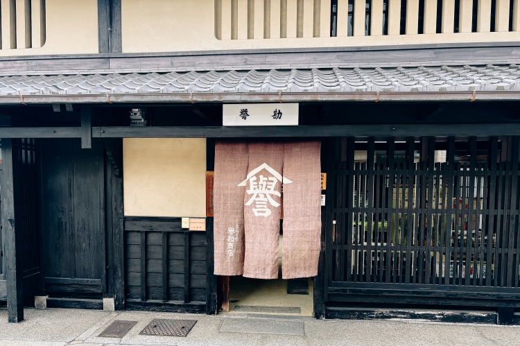 Una digna noren (cortina tradicional japonesa) con el carácter "誉" (honor) prominentemente exhibido.