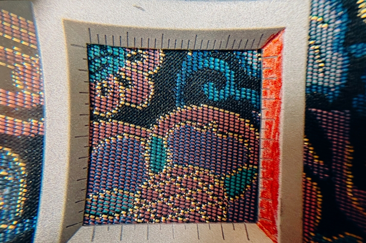Al observarla con una lupa, se aprecia claramente que la tela está tejida con hilos de tres colores diferentes.