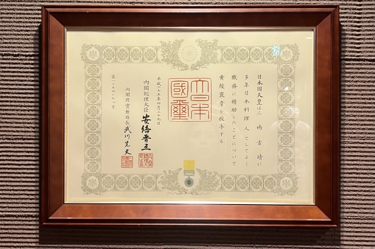 El Sr. Mishima recibió la Medalla de la Cinta Amarilla y la Medalla de la Cinta Azul por sus esfuerzos en la promoción de la cultura de los fideos soba.