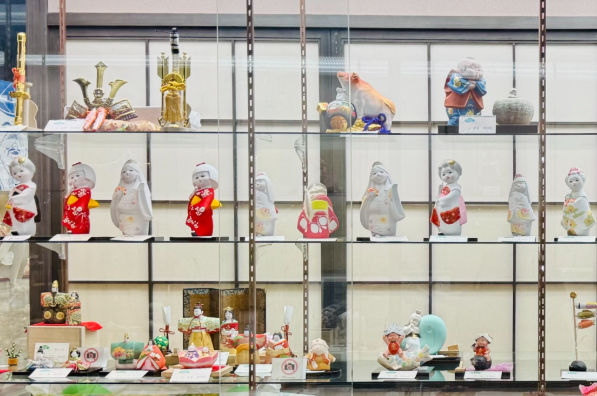 La tienda exhibe una colección de muñecas Hakata, cada una con expresiones y estilos diferentes.